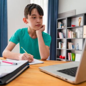Teenage boy having online school class at home Teenage boy having online school class at home